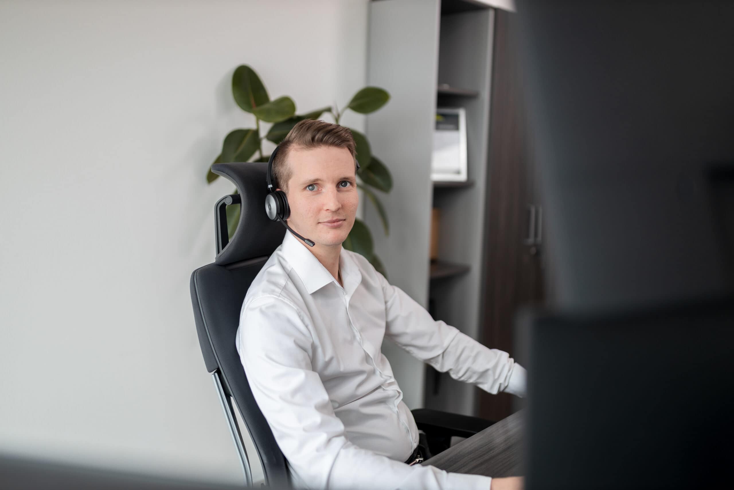 Mitarbeiter mit Headset an seinem Arbeitsplatz.