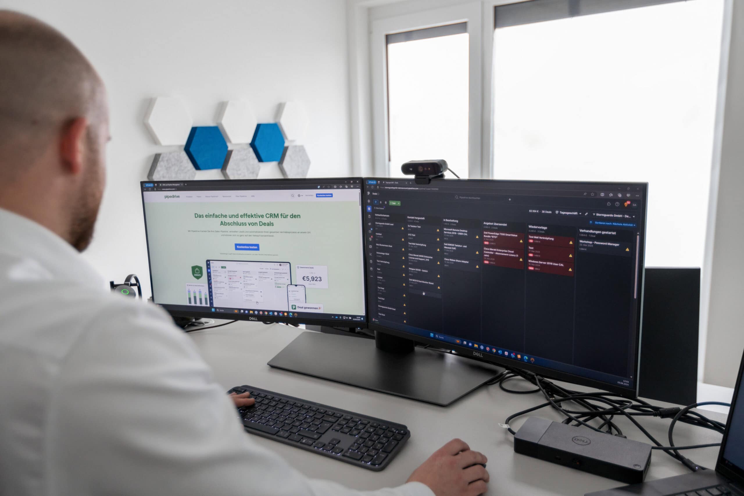 Mitarbeiter arbeitet konzentriert an zwei Bildschirmen mit CRM-System Pipedrive.