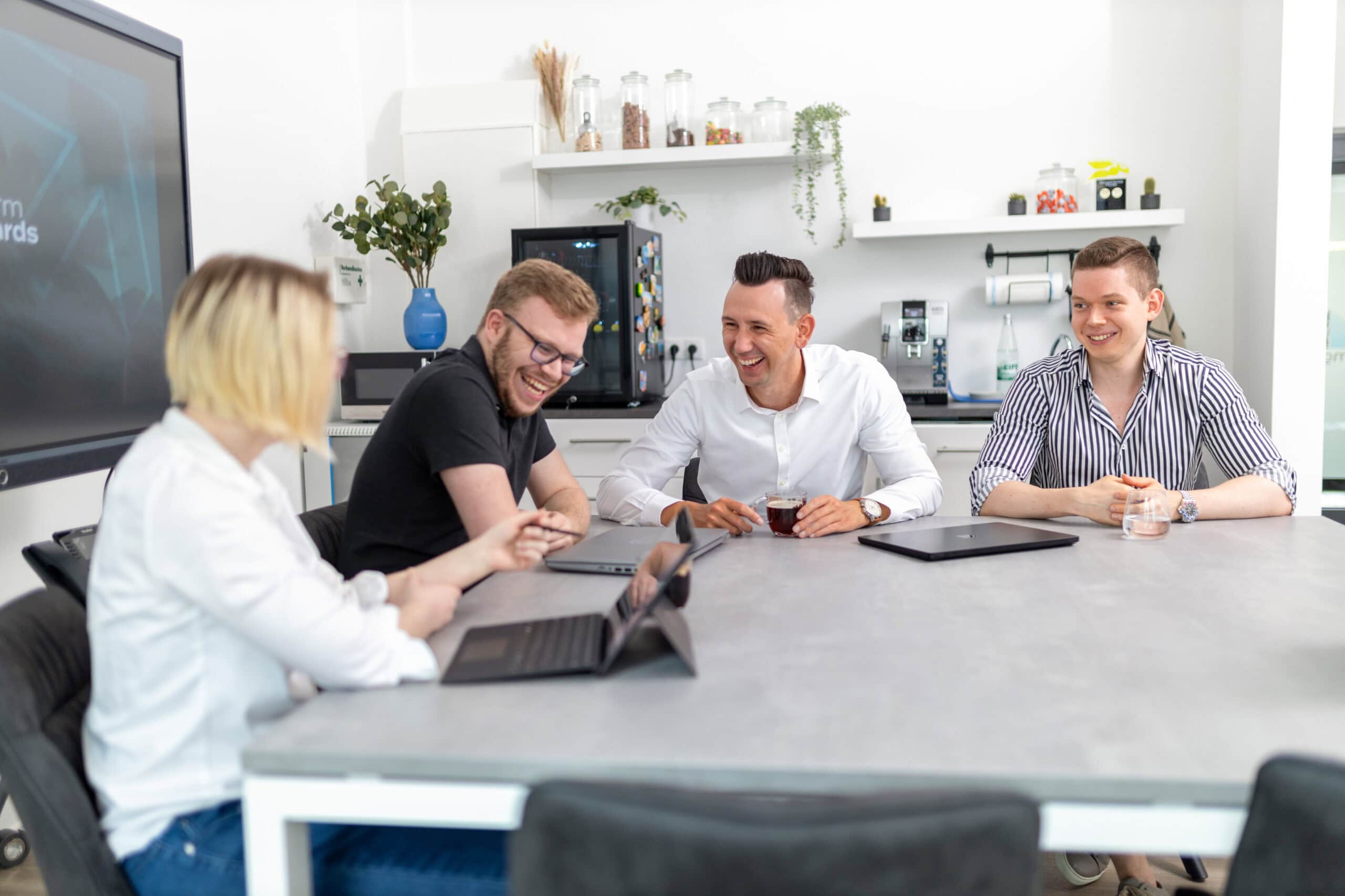 Ausgelassene Teambesprechung im Konferenzraum des Unternehmens.